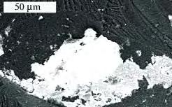 Figure 8. Hematite inclusions, which were most common in the dark gray diamonds, usually occurred as scalelike particles, as shown by the bright white grains in this SEM image (left).
