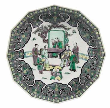 5* A Famille Verte Faceted Bowl, Kangxi Period (1662-1722) of twelve-sided form, depicting scholars gathered around a table, with attendants and youths, the scholar seated with a floorscreen behind