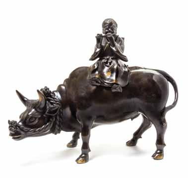 $800-1,200 361* A Japanese Bronze Figure of a Boy Riding an Ox, likely Meiji period, the boy depicted playing a flute, with a woven basket strapped to his back, the ox with a rope twist