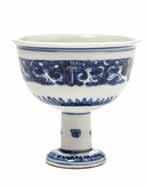 $400-600 88 87* A Blue and White Decorated Porcelain Stem Cup, a circular bowl with everted mouth rim and decorated with archaistic beasts above a repeating leaf band, raised on a cylindrical