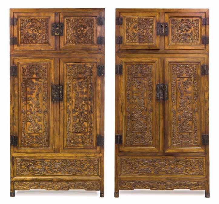 162* A Pair of Chinese Compound Cabinets, the wood of a mellow honeyed tone, the superstructure with circular reserves and the lower cabinets having double doors with relief carved buddhistic lions