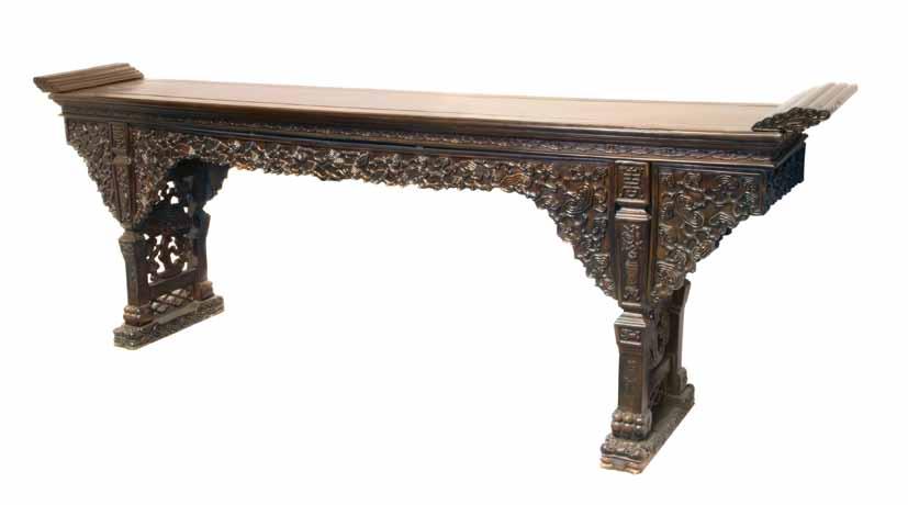 165* A Massive Chinese Carved Hardwood Altar Table, the rectangular plank top with applied, rounded flanges to the top, above a recessed waist with relief carved clouds and flowers, the apron with