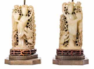 $200-400 238 238* A Pair of Chinese Carved Soapstone Figures, each depicting a lady with coiled coiffure, holding a vessel of flowers and wearing draped robes with a dragon coiled around the base,