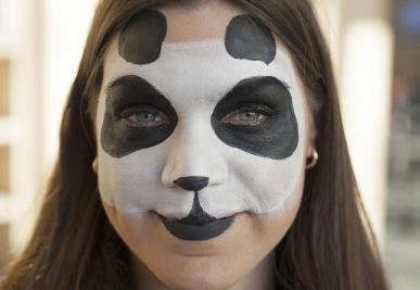 3 Use a brush to outline the panda s face with black paint.