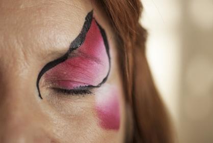 Use a brush to paint two small flower shapes above one eye, in the gap on
