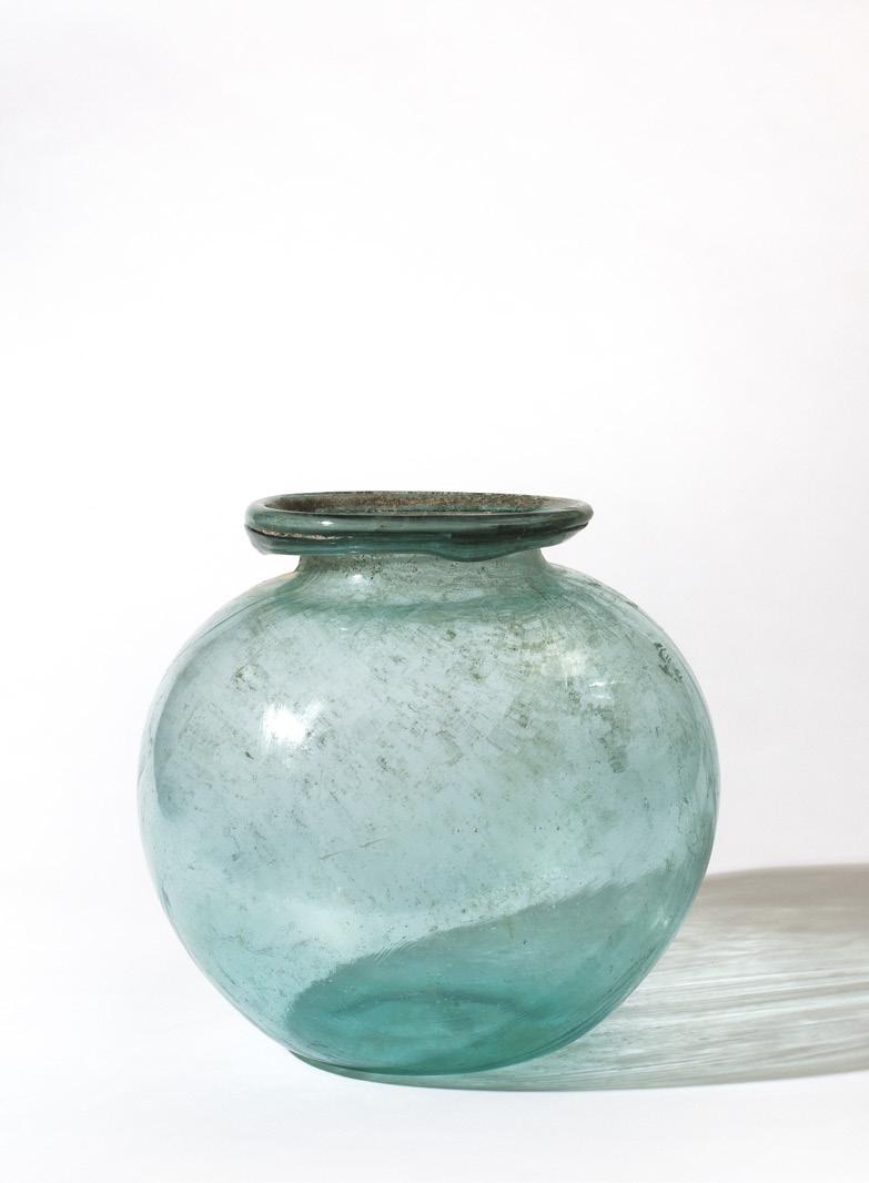 Roman spherical cinerary urn 1st-2nd century AD Glass Height 25.5cm The body free-blown in pale blue-green glass, with cylindrical neck, folded everted rim, underside indented.