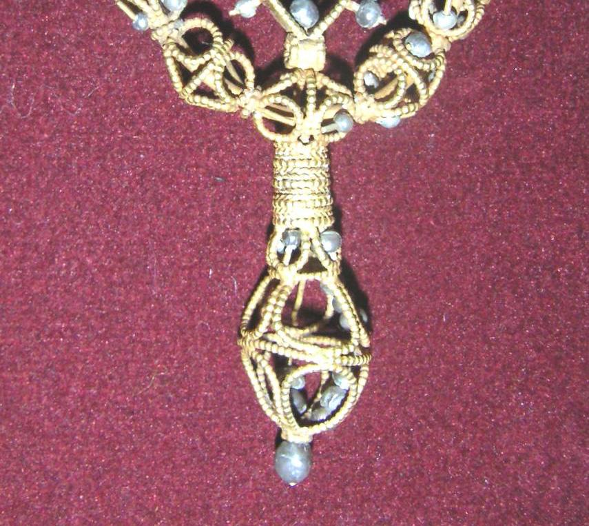 The composition of four-ring pendants is 2.5 cm in length (three pendants of this type). Five of the largest pearls show a weak fluorescence.