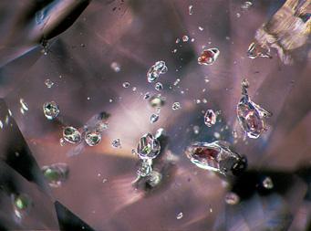 Right: This type I diamond contains inclusions of garnet and pyroxene. Photomicrographs by Thomas H. Gelb and John I.