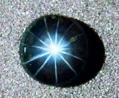 This yellowish brown, slightly translucent tourmaline (13.14 ct) with man-made asterism displays a 12-rayed, asymmetric star with additional satellite lines in the center of the sample.