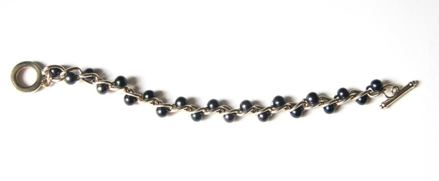 strand of black pearls on gold with the