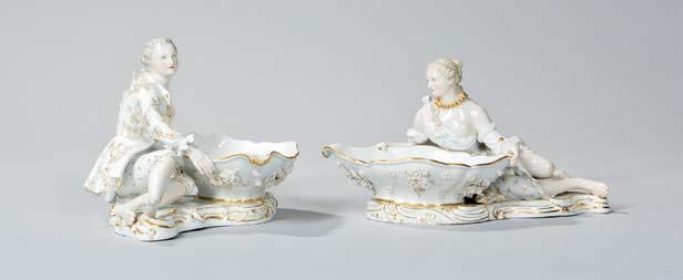 325 325 Pair of Meissen Porcelain Figural Dishes, Germany, late 19th/early 20th century, white ground with gilding, each holding a serpentine-rimmed ovoid dish on scrolling base, factory