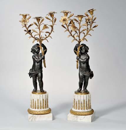 388 Pair of Gilt-bronze Figural Candlesticks, France, 19th century, each with a patinated figure of a draped putto issuing a three-light vine-wrapped armature with floriform drip cups, standing on a