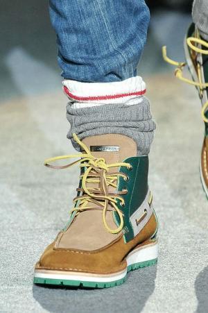 Classic work boots are modernised with contrast and stitching in bright green and red against black.