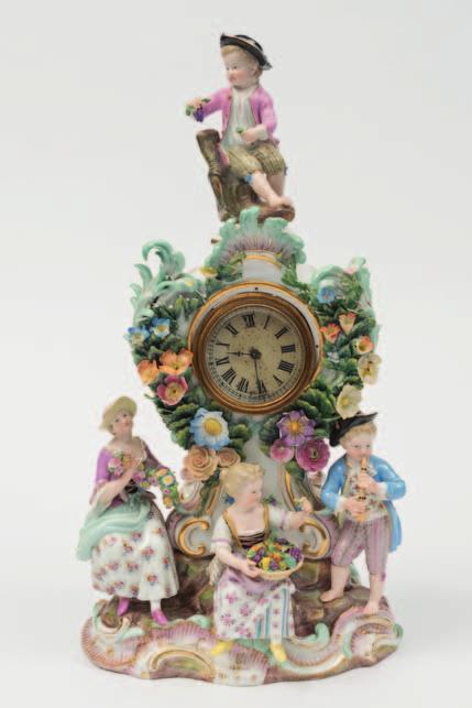 617 A Meissen porcelain figural mantel clock of neo rococo cartouche outline applied with flowers, the scroll base with a standing male musician and two seated female figures, one with a garland the