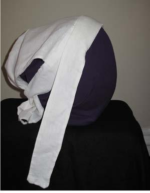 The prototype is made from three pieces of linen: a long scarf that covers the hair is sewn into a double-layered H-shaped piece that forms the two ties.