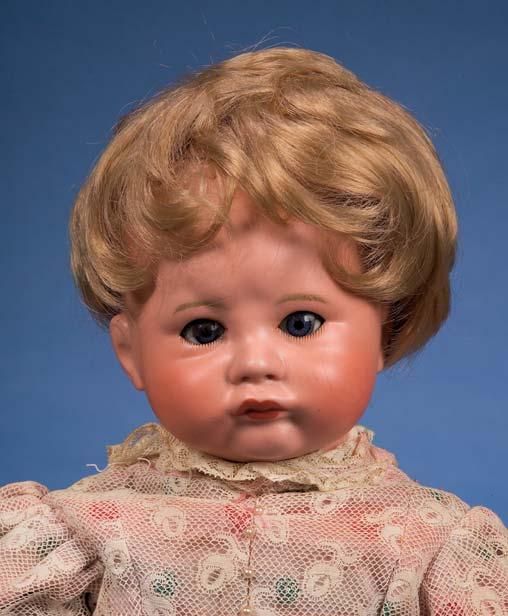Kley & Hahn 549 Bisque Character Girl, impressed K&H 549 8 Germany, with closed mouth modeled in slight smile, dimpled cheeks and chin, narrowed weighted brown glass eyes, pierced ears, blonde mohair