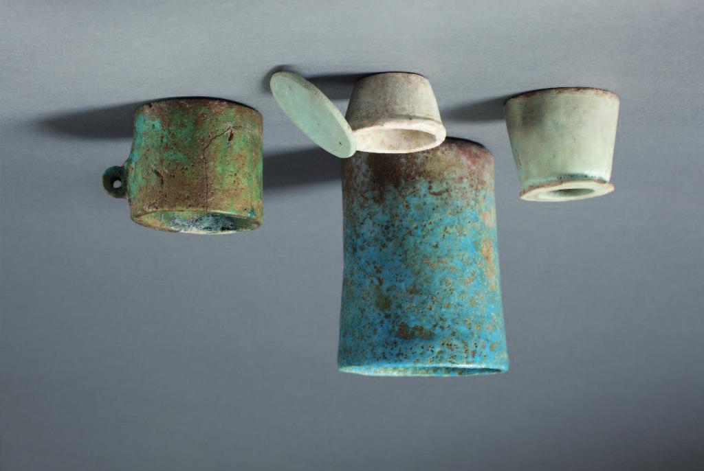 19 Miniature Egyptian cup in blue-green faience with straight sides and flat base, small loop handle on the side. Late Dynastic Period, c.600 BC, or earlier. Height 3.4cm.