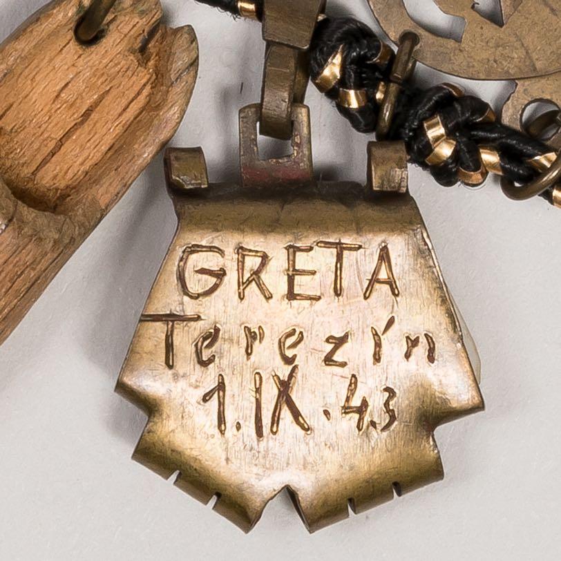 8. Ceramic shard in the shape of a pentagon, inscribed on the back, Greta Terezín 1.IX.43 A similar charm (no. 12) is inscribed Theo Terezín 1.IX.43. Theo and Greta may have had a romance at the camp.