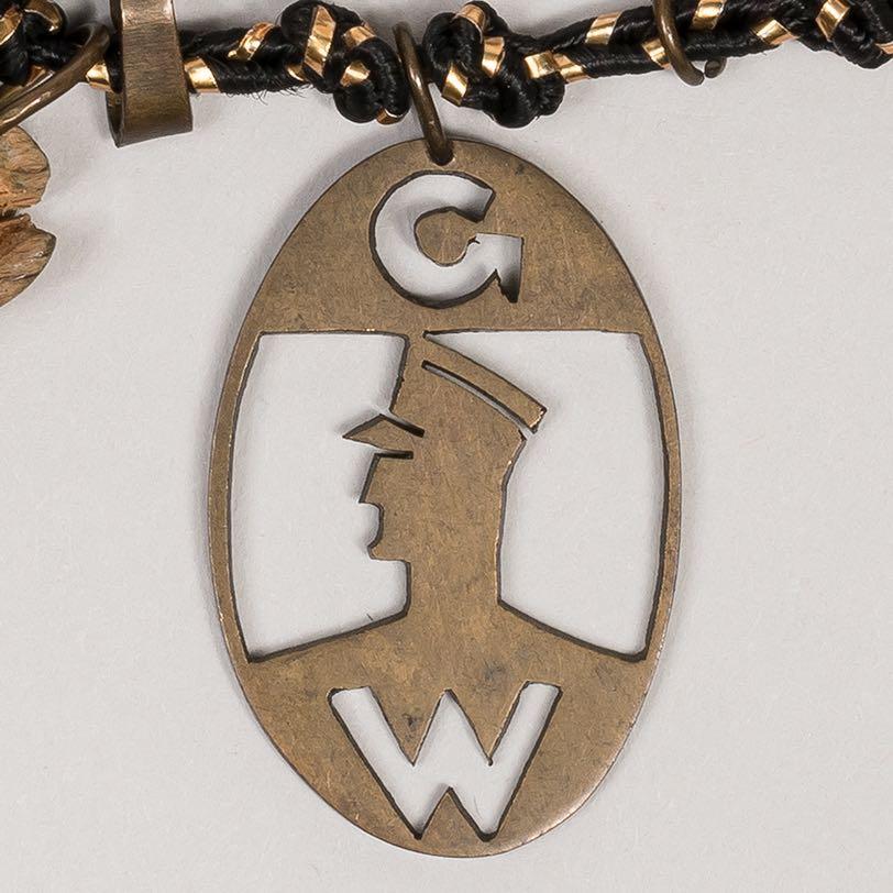 9. Oval badge with profile of a policeman and the initials GW, for Ghettowache The Ghettowache, or Ghetto Police, composed of male prisoners under age forty-five, was established by the Nazis on