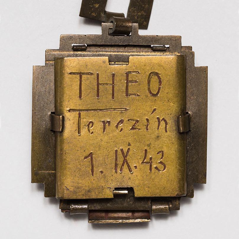 12. Ceramic shard in the shape of a pentagon inscribed on the back Theo Terezín 1.IX.43 The ceramic shards used in this charm and its companion (no.