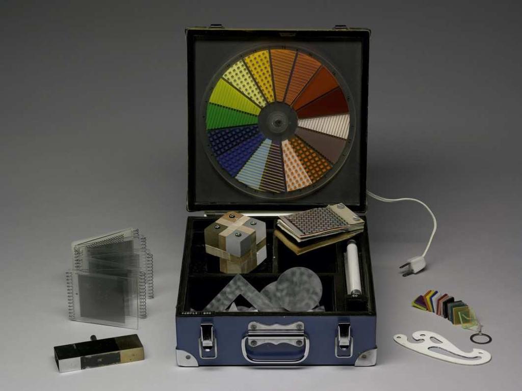 Figure 2. Gerald Laing and Peter Phillips, Hybrid Sample Box, 1965, box with mounted Plexiglas wheel and various sample materials, box closed: 11.1 x. 25.4 x 27 cm.