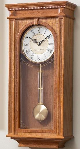 C4419 Bulova Clock. MANORCOURT. From the Manor Collection. Wood case, golden oak finish. Brass finish metal dial and pendulum.