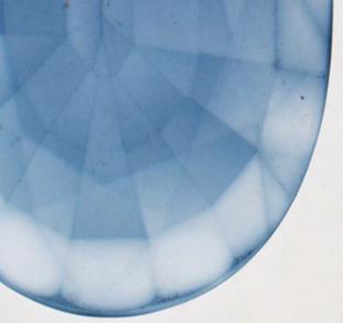 Figure 17. Viewed in immersion, the varying coloration and color concentrations along facet junctions and the girdle indicate that this sapphire was repolished after undergoing diffusion treatment.