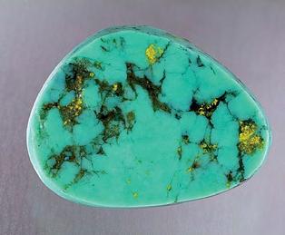 Figure 19. The GIA Laboratory recently examined turquoise beads and cabochons represented as coming from China, which have bright yellow inclusions of uranium-bearing francevillite.