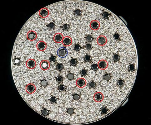 Figure 27. In this ring, the 13 red circles are black diamonds and the other 30 black stones are synthetic moissanite, one of which has crystalline silicon inclusions (blue circle). Photo by Li Haibo.