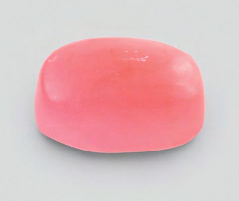 Figure 31. This 14.32 ct alabaster cabochon proved to be dyed; note its resemblance to opal or chalcedony. Also note the whitish chipped areas on the dome due to its very low hardness. Photo by G.