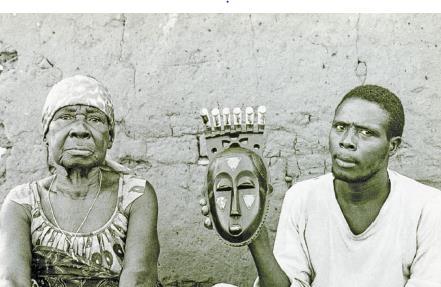 Portrait mask [Mblo] Early 20 th century Contextual photograph Baule peoples [Côte d'ivoire] This specific mask represents Moya Yanso, pictured here with a family member holding her mask.