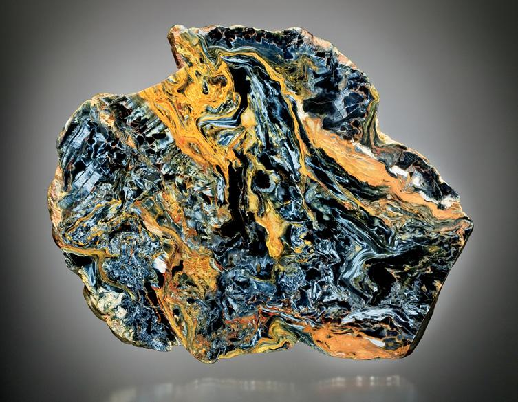 Figure 8. This slab of pietersite (12 cm across) shows the colorful appearance and brecciated texture that are typical of fine Namibian material. Photo by John Passaneau.