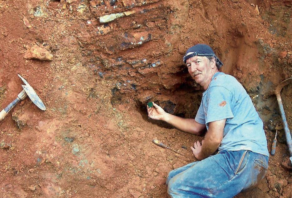 Figure 13. Miner Terry Ledford displays the large emerald crystal next to the pocket where it was found in August 2009 in Hiddenite, North Carolina.