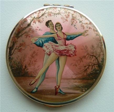 Kigu ballet. Transfer printed ballet dancers against a background of trees with pink tones as in a stage set. Inner lid with Kigu trademark on a textured surface and a sliding catch. Framed mirror.