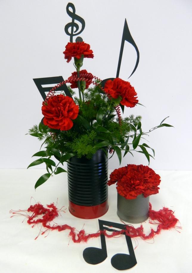 Banquets: Band or Music Banquet Flowers/Supplies needed: 1 Large tin can 1 Small tin can 8 Red carnations 3 Sstems Ruskus 1 Block soaked Oasis trimmed to fit container 1 Yard red yarn Other Greens
