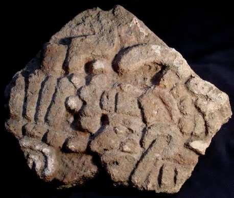 Figure 23: Slab showing the face of a personage wearing an elaborate headdress on the head and forehead.
