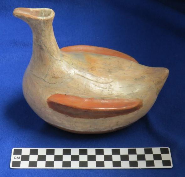 228 Catalog: Unknown / Accession: Unknown Author s Description: Red and cream painted duck effigy vessel where the head serves as the spout. Measurements: Height of Vessel = 16.