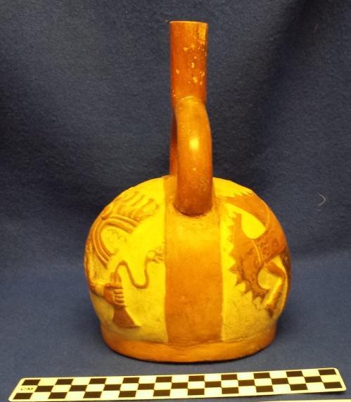 Brown 1979 How Acquired: Gift Remarks: #52575 is a duplicate from the same mold Author s Description: Red and cream-colored stirrup-spout bottle with mythical fish holding tumi with snake attached to