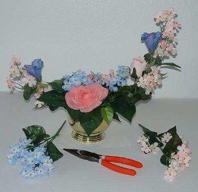 Step 5. Insert secondary flowers into the arrangement, spacing them evenly and staying within the crescent form. I used pink and blue phlox flowers as secondary flowers.