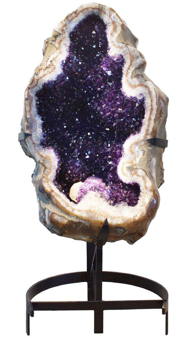GIANT OVAL AMETHYST GEODE WITH CALCITE This truly unique amethyst geode, standing 4 ½ feet tall, with an interior opening that is over a foot deep, came from a mine near the city of Artigas in