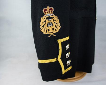 arm - centrally, bottom edge of badge 10mm above sleeve slash Bandmaster rank badge: Embroidered lyre in laurel wreath, surmounted by crown
