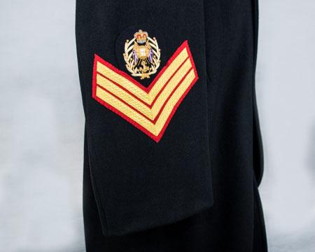 Effective October 2017 CSgt rank badge: Embroidered globe on crossed flags with a fouled anchor below in a laurel wreath surmounted by a crown (gold on dark blue) BRd 3(1) Lower right arm -