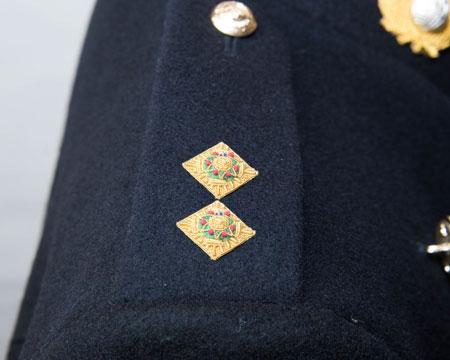 either side of the collar fastening edge set centrally within the collar band with the centre of the badge 50mm from outside edge of the collar Lieutenant Colonel rank badge: Embroidered crown (gold