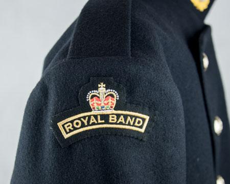 Effective October 2017 ROYAL BAND shoulder flash: Embroidered letters surmounted by a crown (gold on dark blue) BRd 3(1) Below right shoulder (Note 1) - centrally, top edge of badge 20mm below