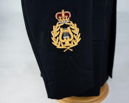 rank badge: Embroidered lyre in laurel wreath, surmounted by crown (gold on dark blue) Lower right arm - centrally, bottom edge of badge 10mm above point of sleeve slash Drum Major