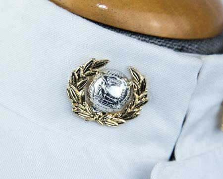 centrally, bottom edge of letters 10mm above shoulder seams Globe & Laurel: Officer and WO1 (silver globe anodized laurel)