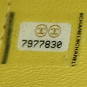 Seven digit serial number printed on white sticker covered with clear tape with two Chanel logos. Gold speckles appear throughout sticker.