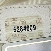 4XXXXXX 1996 to 1997 0's have strikethroughs. 1's are sans-serifs (no feet). Seven digit serial number printed on white sticker covered with clear tape with two Chanel logos.