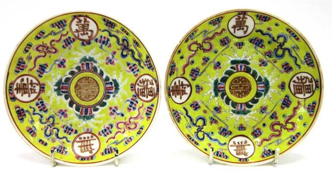 Century, on wood stand, 10cm diameter Lot 219 219 A MATCHED PAIR OF CHINESE YELLOW GROUND SAUCERS Iron red six character Guangxu marks to base,