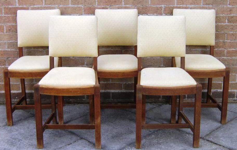 Lot 352 Lot 349 349 ATTRIBUTED TO HEALS - A SET OF FIVE OAK DINING CHAIRS With cream upholstered back rests and drop-in seats, on square supports joined by stretcher